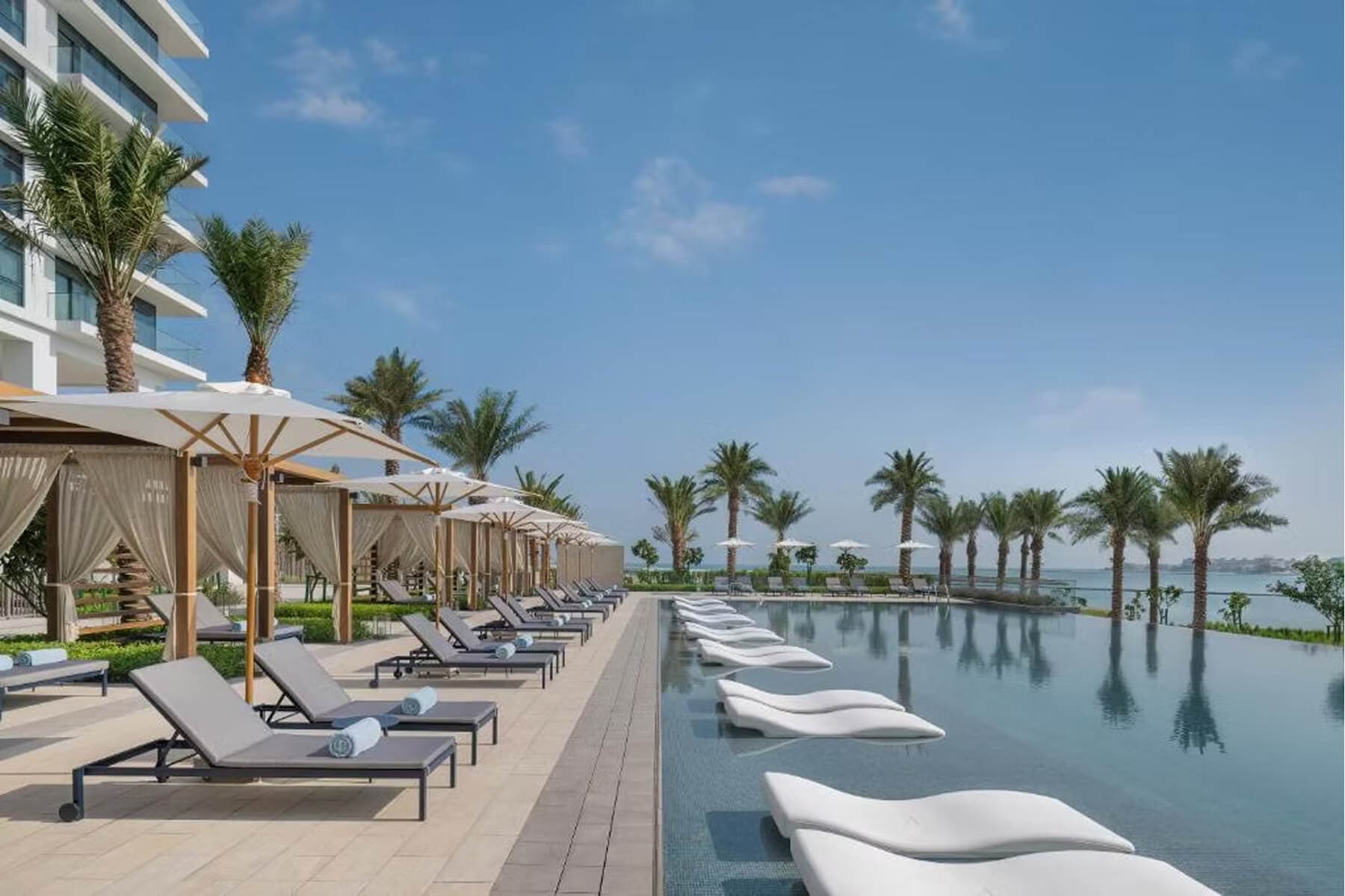 Waterfront resort pool with Vantaro Terra outdoor loungers